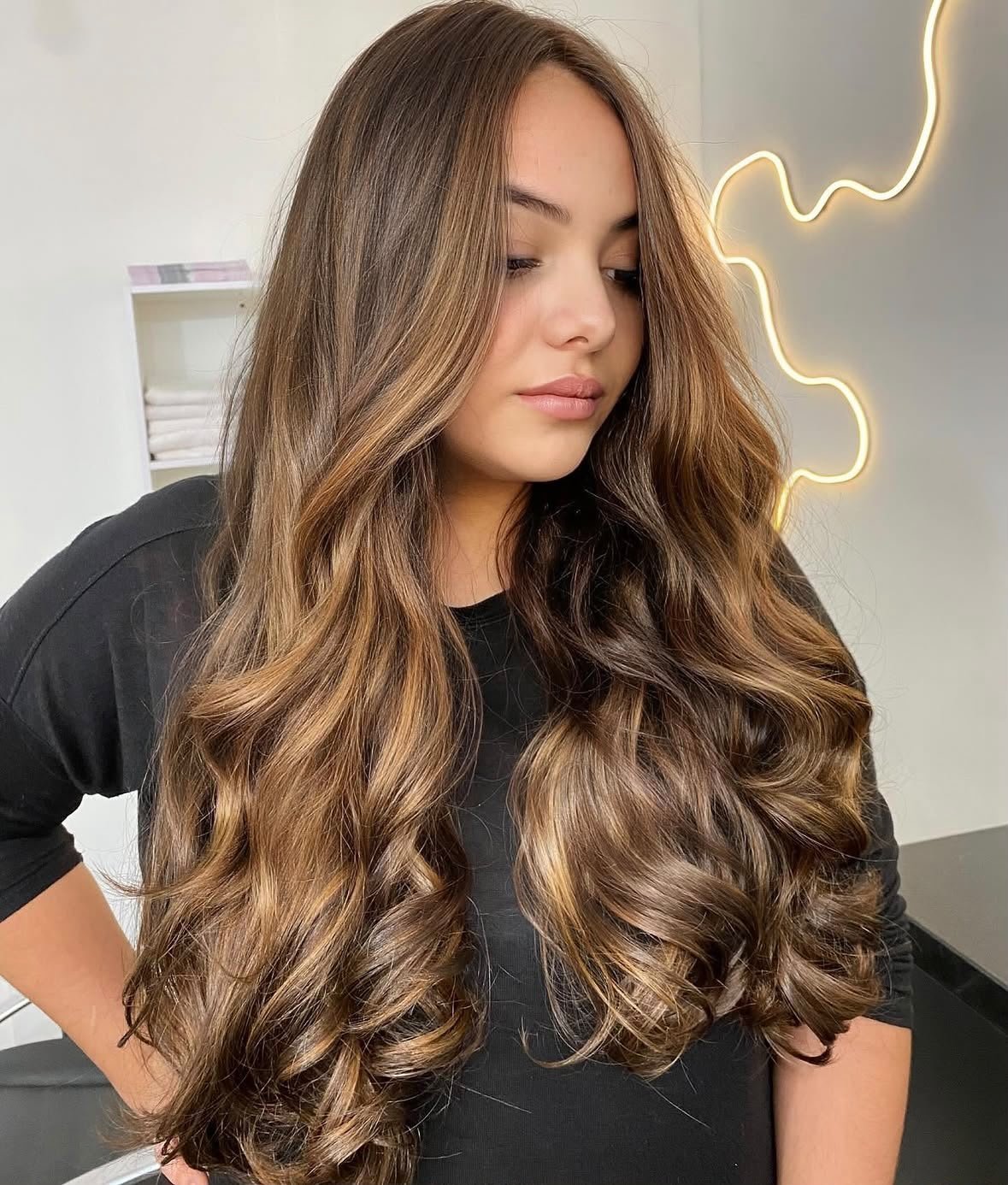 Cabelo castanho iluminado e ondulado